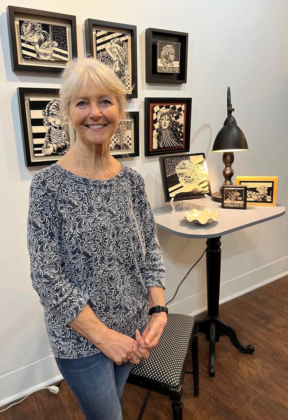 Laura Donnelly, a resident artist at Market Street Art Spot, is shown with her artwork in the new and expanded location of the art gallery in downtown Minerva.