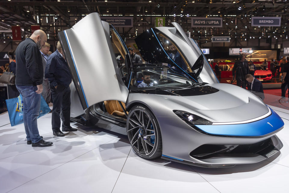 Visitors look at the new Automobili Pininfarina 'Battista' during the press day at the '89th Geneva International Motor Show' in Geneva, Switzerland, Tuesday, March 05, 2019. The 'Geneva International Motor Show' takes place in Switzerland from March 7 until March 17, 2019. Automakers are rolling out new electric and hybrid models at the show as they get ready to meet tougher emissions requirements in Europe - while not forgetting the profitable and popular SUVs and SUV-like crossovers. (Martial Trezzini/Keystone via AP)