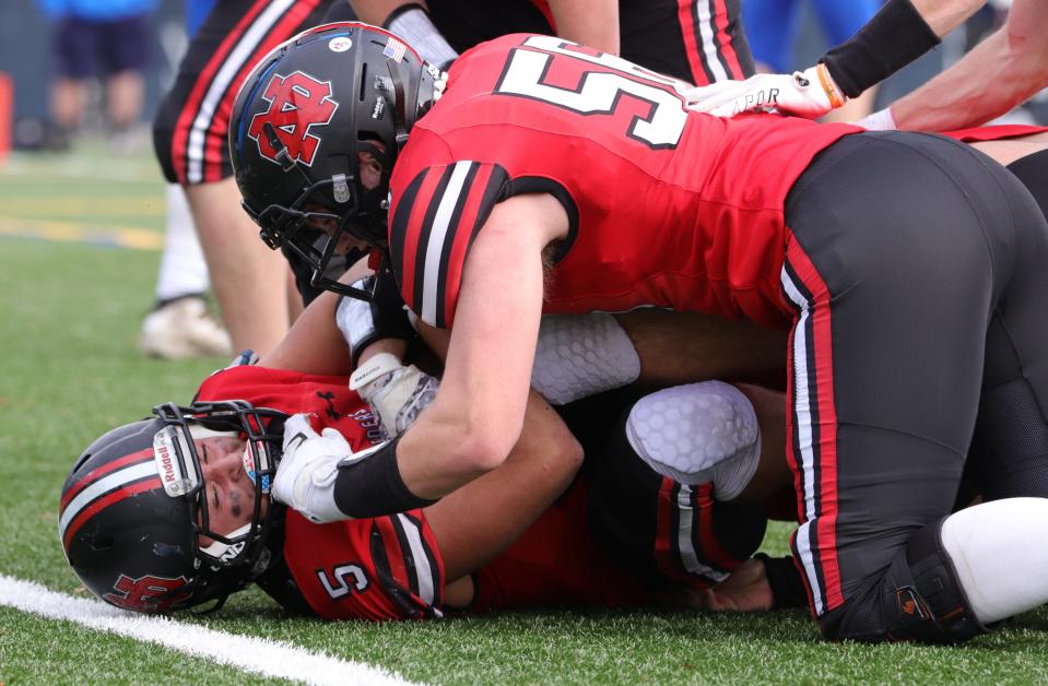 The North Quincy High football team piled on running back Nate Caldwell after a touchdown during the 89th annual Thanksgiving game against Quincy at Veteran's Memorial Stadium in Quincy on Thursday, November 25, 2021.