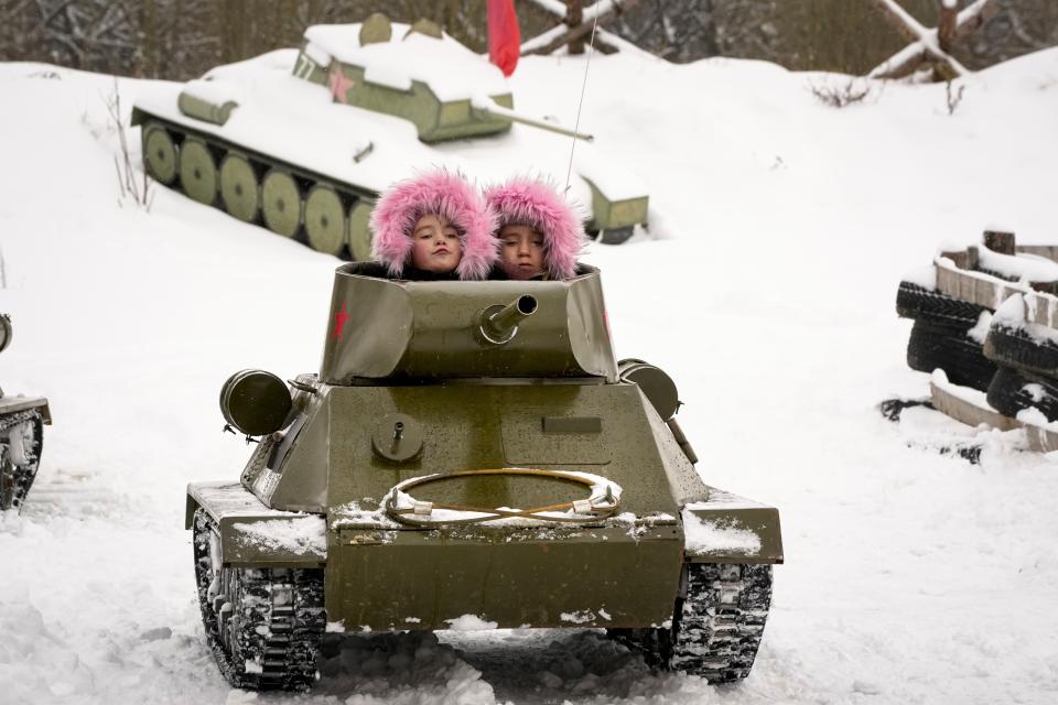 Children ride a model of World War II-era Soviet T-34 tank during a military historical festival at the family historical tank park outside St. Petersburg, Russia, Saturday, Feb. 4, 2023. (AP Photo/Dmitri Lovetsky)