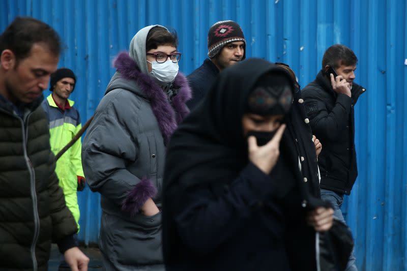 An Iranian woman wears protective mask to prevent contracting a coronavirus, as she walks at Grand Bazaar in Tehran