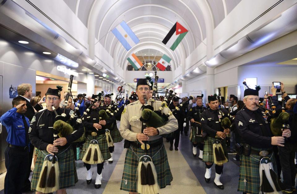 A bagpiper leads a procession through Terminal 4 at LAX with the U.S. Honor Flag as it arrives at Los Angeles International Airport