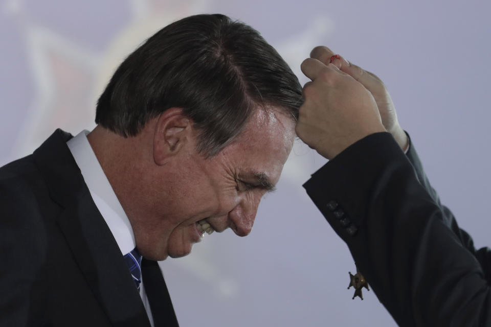 FILE - Brazil's President Jair Bolsonaro receives the Maua Merit Medal for services to the national infrastructure, in Brasilia, Brazil, Aug. 15, 2019. Bolsonaro’s benevolence in decorating ideological allies, ministers, loyalists and family comes as little surprise — sometimes on questioned grounds. Bolsonaro himself has received six medals from his own administration. (AP Photo/Eraldo Peres, File)