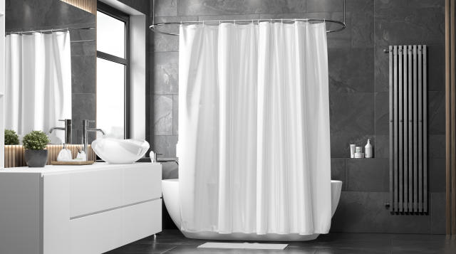Blank white closed shower curtain in a modern bathroom.