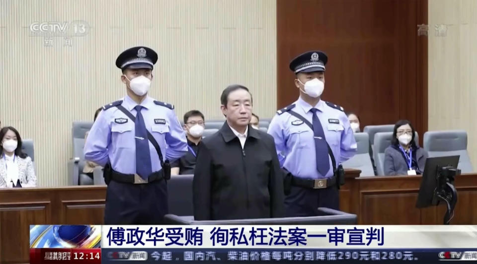 In this image taken from video footage run by China's CCTV, former Chinese justice minister Fu Zhenghua is escorted by court police as he attends a court session for his verdict announcement in Changchun, northeastern China's Jilin province on Thursday, Sept. 22, 2022. The former Chinese justice minister was sentenced to death with a two-year reprieve on charges of taking bribes and helping criminals including his brother hide illegal activity, state TV reported Thursday. (CCTV via AP)