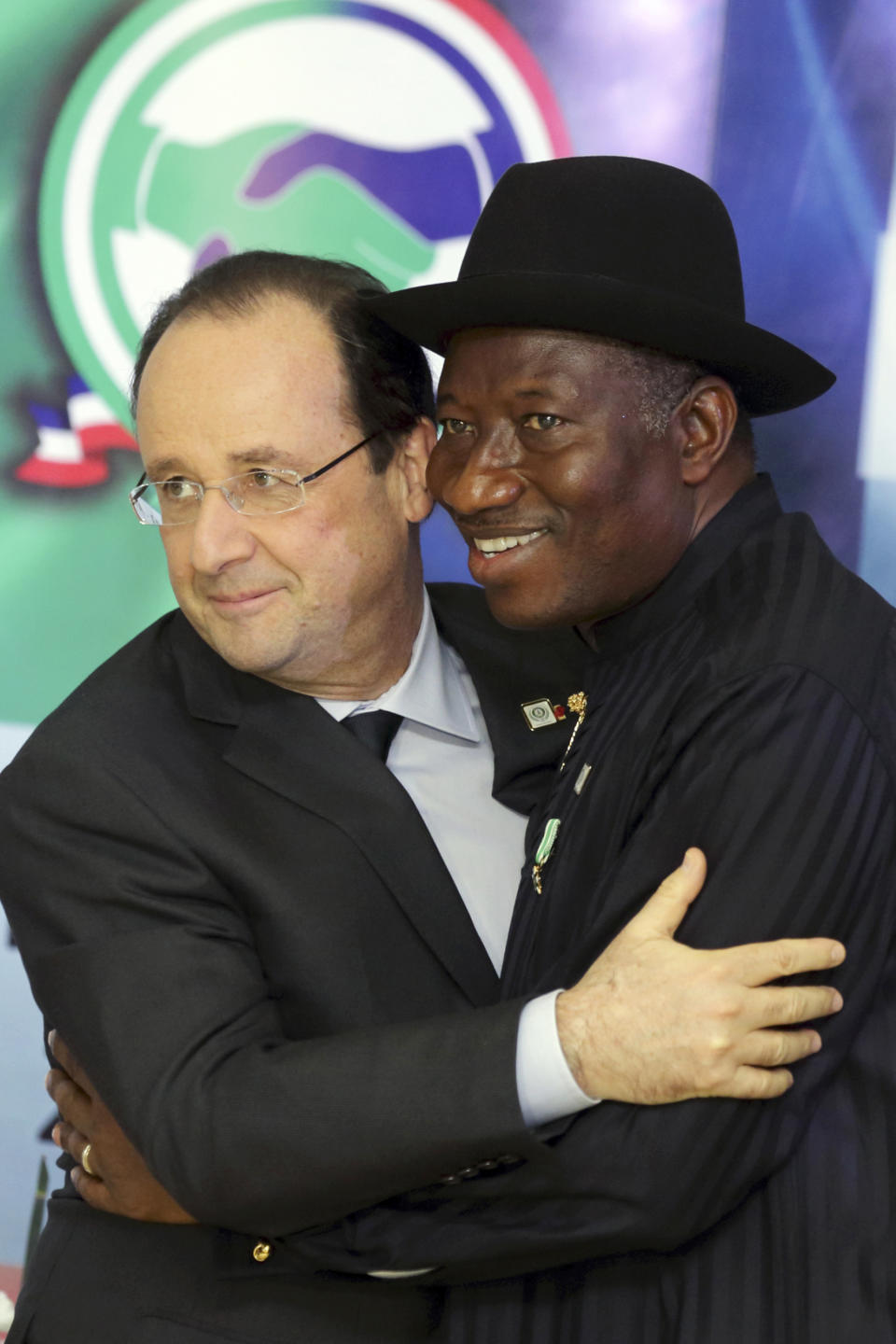 Nigerian President Goodluck Jonathan, right, embraces French President Francois Hollande after they opened the Nigeria-France business forum in Abuja, Nigeria, Thursday, Feb. 27, 2014. Hollande is in Nigeria for a one-day official visit. (AP Photo/Philippe Wojazer, Pool)