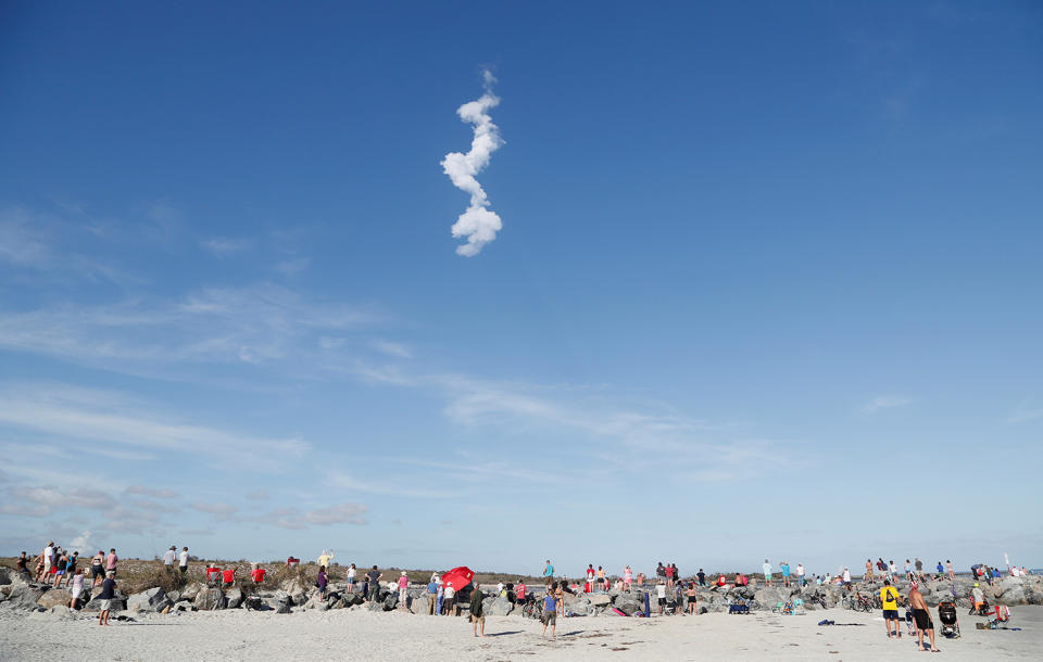 <p>The contrail of SpaceX’s first Falcon Heavy rocket loom above spectators at Cocoa Beach after its launch from the Kennedy Space Center, Fla., Feb, 6, 2018. (Photo: Gregg Newton/Reuters) </p>