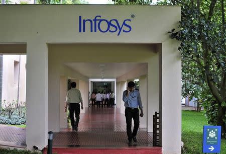 Employees walk along a corridor in the Infosys campus in the southern Indian city of Bangalore September 23, 2014. REUTERS/Abhishek Chinnappa