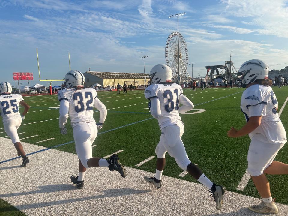 Members of the Timber Creek High School football team warm up before Sunday's game against rival Highland to close out the third annual Battle at the Beach showcase in Ocean City.