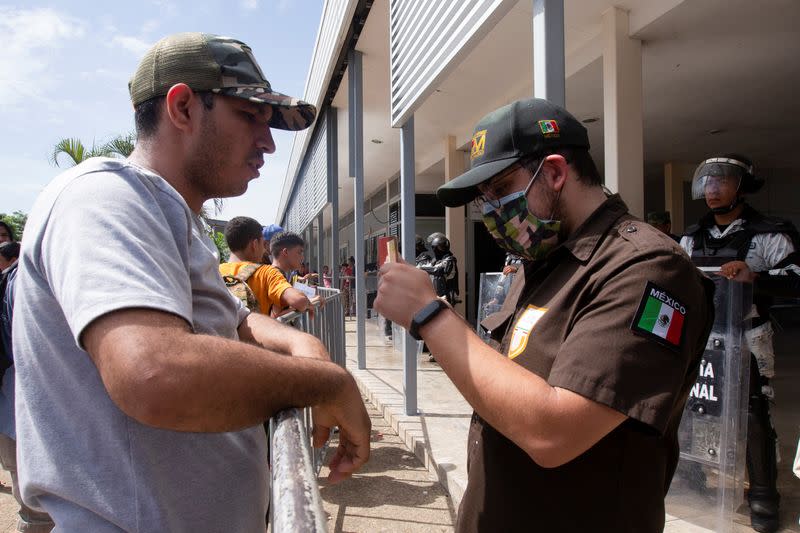 Migrants queue an to get documents to cross the country towards the U.S. border, at an office of the National Institute of Migration in Huixtla