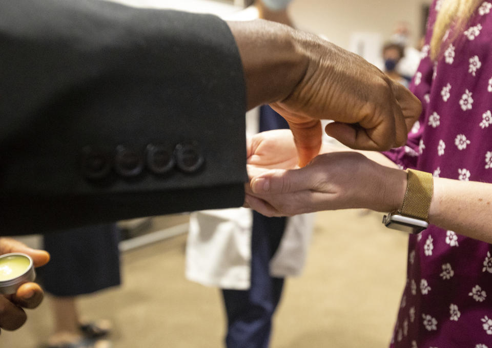 Father Don Ajoko, Phd. anoints the hands of healthcare workers and members of the nearly three dozen healthcare workers from around the country to help supplement the staff at Our Lady of the Lake Regional Medical Center in Baton Rouge, La., Monday, Aug. 2, 2021. Louisiana has one of the lowest coronavirus vaccination rates in the nation and is seeing one of the country’s worst COVID-19 spikes. (AP Photo/Ted Jackson)