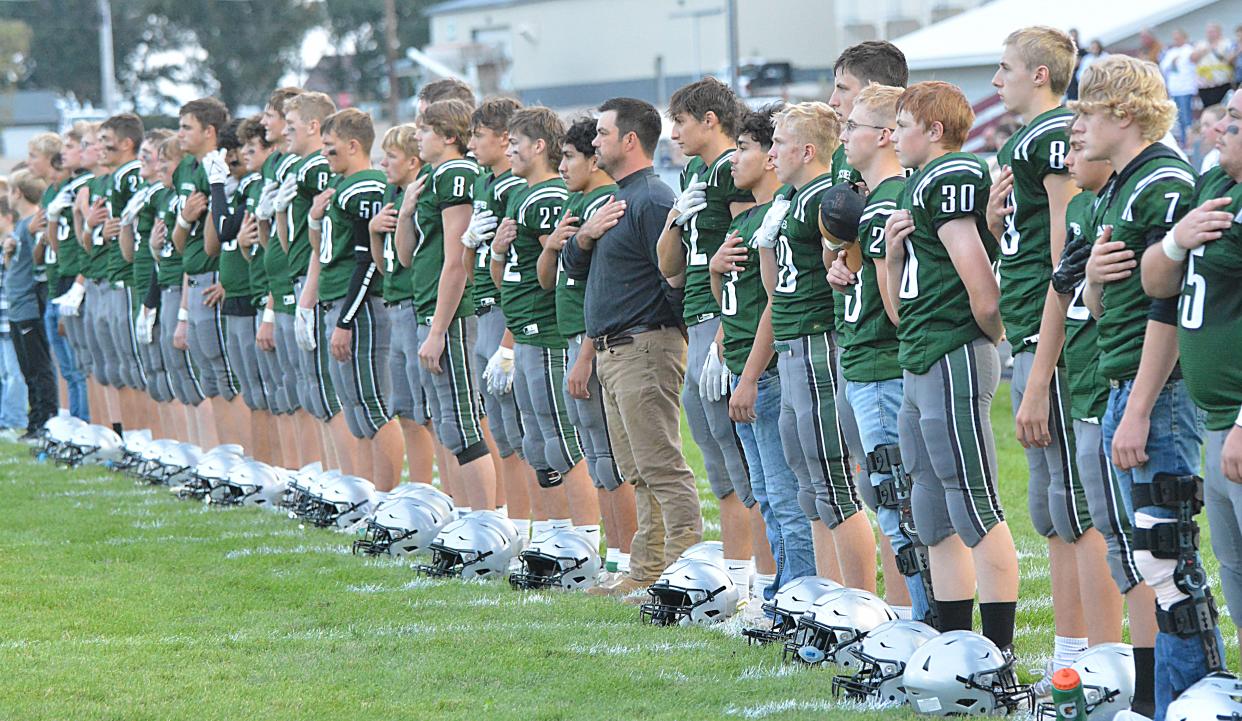 Clark-Willow Lake head coach Dave Severson (tan pants) and Cyclone players stand for the national anthem prior to their high school football game against Mobridge-Pollock on Friday, Sept. 22, 2023 in Clark.