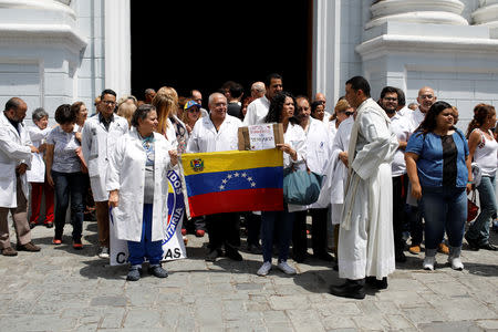 Venezuelans, including doctors, gather outside a church after a mass during an ongoing blackout in downtown Caracas, Venezuela March 10, 2019. REUTERS/Marco Bello