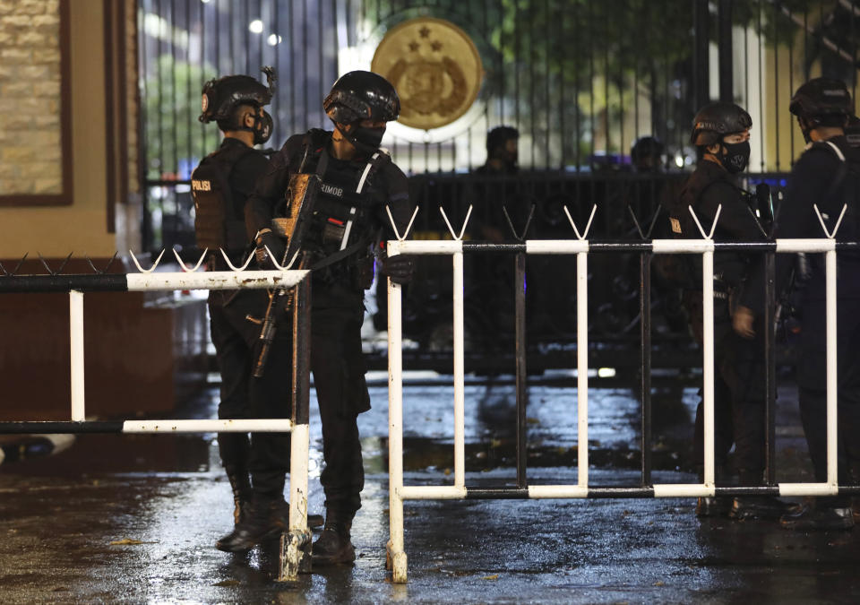 Officers set up a barricade at the gate of the National Police Headquarters following a suspected militant attack in Jakarta, Indonesia, Wednesday, March 31, 2021. A woman entered the Indonesian National Police Headquarters in Jakarta and pointed a gun at several officers before being shot dead by police, in the latest in a series of militant attacks in the world's most populous Muslim nation. (AP Photo/Dita Alangkara)