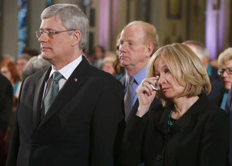 Laureen Harper (R) wife of Canadian Prime Minister Stephen Harper (L) wipes away a tear at the state funeral of Canada's former finance minister Jim Flaherty in Toronto, April 16, 2014.