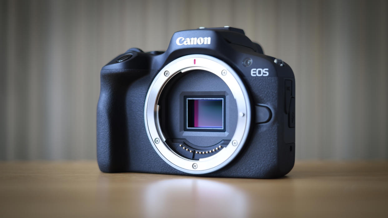  Canon EOS R100 camera on table with striped background 