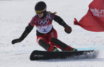 FILE - Switzerland's Patrizia Kummer competes in her women's snowboard parallel giant slalom semifinal at the Rosa Khutor Extreme Park, at the 2014 Winter Olympics, Wednesday, Feb. 19, 2014, in Krasnaya Polyana, Russia. Three weeks alone in a hotel room is hardly an ideal setting for a snowboarder preparing for the Olympics. Kummer, a Swiss competitor who won a gold medal at the 2014 Sochi Olympics, is unvaccinated against the coronavirus by choice, so she is spending 21 days in isolation in China before the Winter Games begin in Beijing on Feb. 4.(AP Photo/Sergei Grits, File)