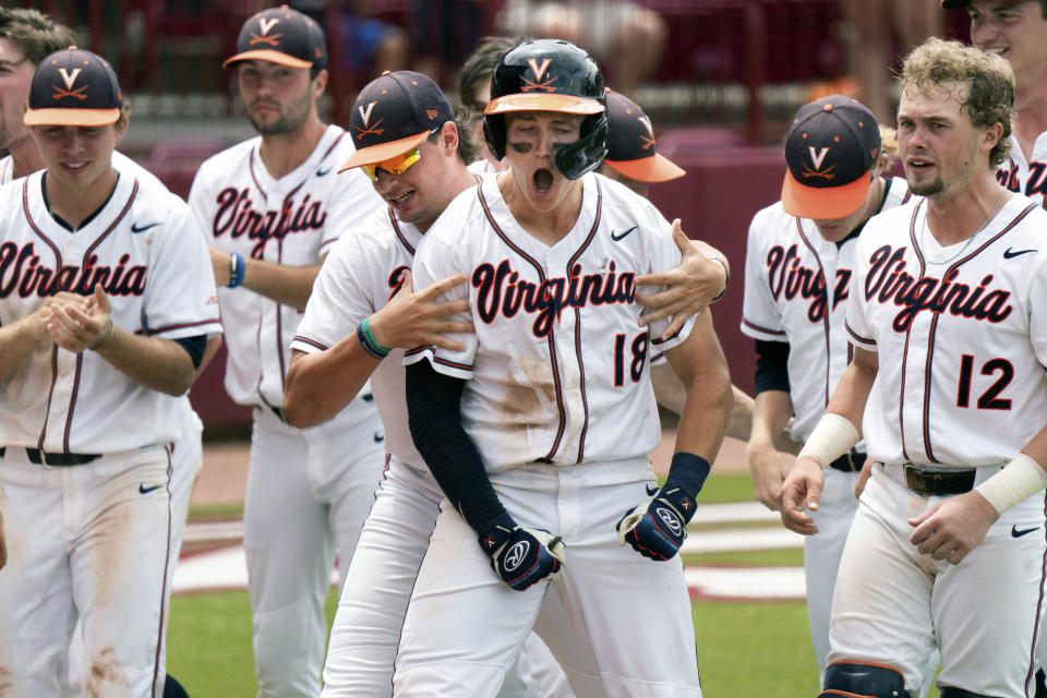 Virginia's Zack Gelof (18) celebrates his eighth inning home run with Christian Hlinka, left, Logan Michaels (12) and other teammates during an NCAA college baseball tournament super regional game against Dallas Baptist Sunday, June 13, 2021, in Columbia, S.C. Virginia won 4-0. (AP Photo/Sean Rayford)