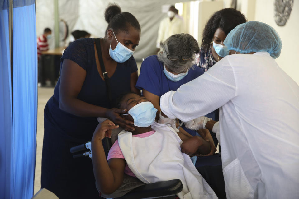 FILE - A health worker gives a youth a shot of the Moderna vaccine for COVID-19 at Saint Damien Hospital in Port-au-Prince, Haiti, Tuesday, July 27, 2021. According to the Pan American Health Organization, after more than a year from the launch of the first COVID-19 vaccine, Haiti has only managed to vaccinate less than 1% of its population, becoming the one country in the Americas with the least access to the vaccines. (AP Photo/Odelyn Joseph, File)