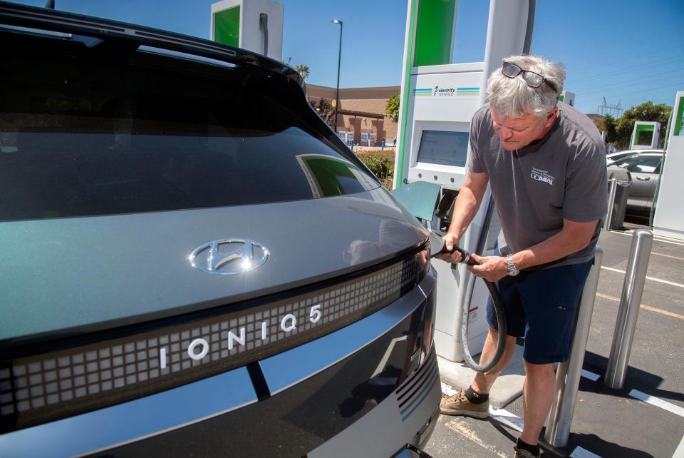 Dru Sutton attaches a charger to his Hyundai Ioniq 5 electric vehicle at the Electrify America charging station Wednesday at the Walmart on Trinity Parkway in Stockton.