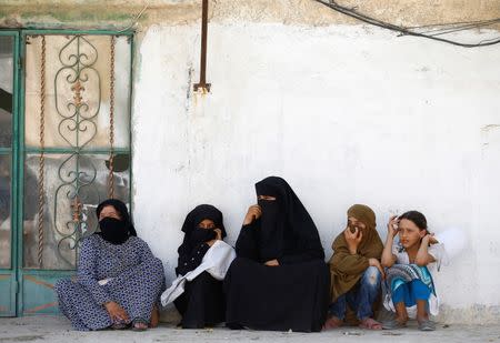 Women sit in front of their home in the border town of Jarablus, Syria. REUTERS/Umit Bektas