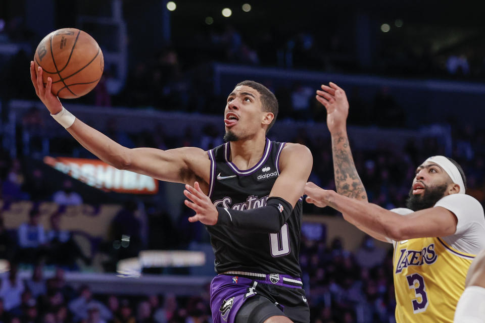 Sacramento Kings guard Tyrese Haliburton (0) goes to basket while defended by Los Angeles Lakers forward Anthony Davis (3) during the second half of an NBA basketball game in Los Angeles, Friday, Nov. 26, 2021. The Kings won 141-137 in triple overtime. (AP Photo/Ringo H.W. Chiu)