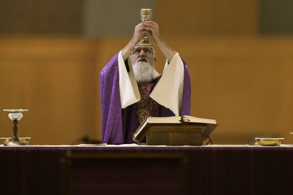 Rev. Gabriel Landis prepares Communion during a Catholic Mass at Benedictine College Sunday, Dec. 3, 2023, in Atchison, Kan. (AP Photo/Charlie Riedel)