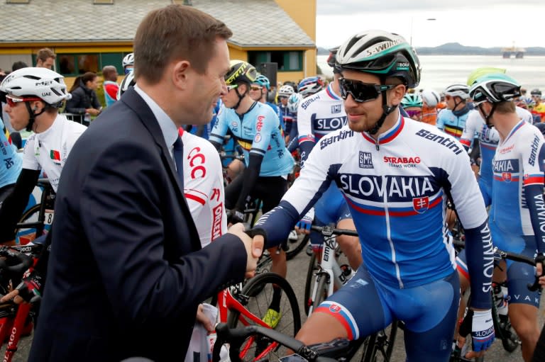 Peter Sagan saluda al presidente de la UCI, David Lappartient. El directivo francés es partidario de regular más o erradicar el pinganillo en el ciclismo. / Foto: AFP