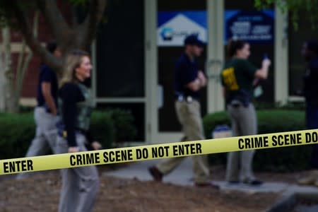 Federal agents are seen behind crime scene tape after executing search warrants on multiple businesses in Lawrenceville