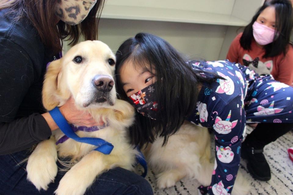 Ann Cox (left) and her therapy dog Augie from Creature Comfort Pet Therapy visit with children from the Education, Careers and Lifelong Community of Chatham in December 2021.