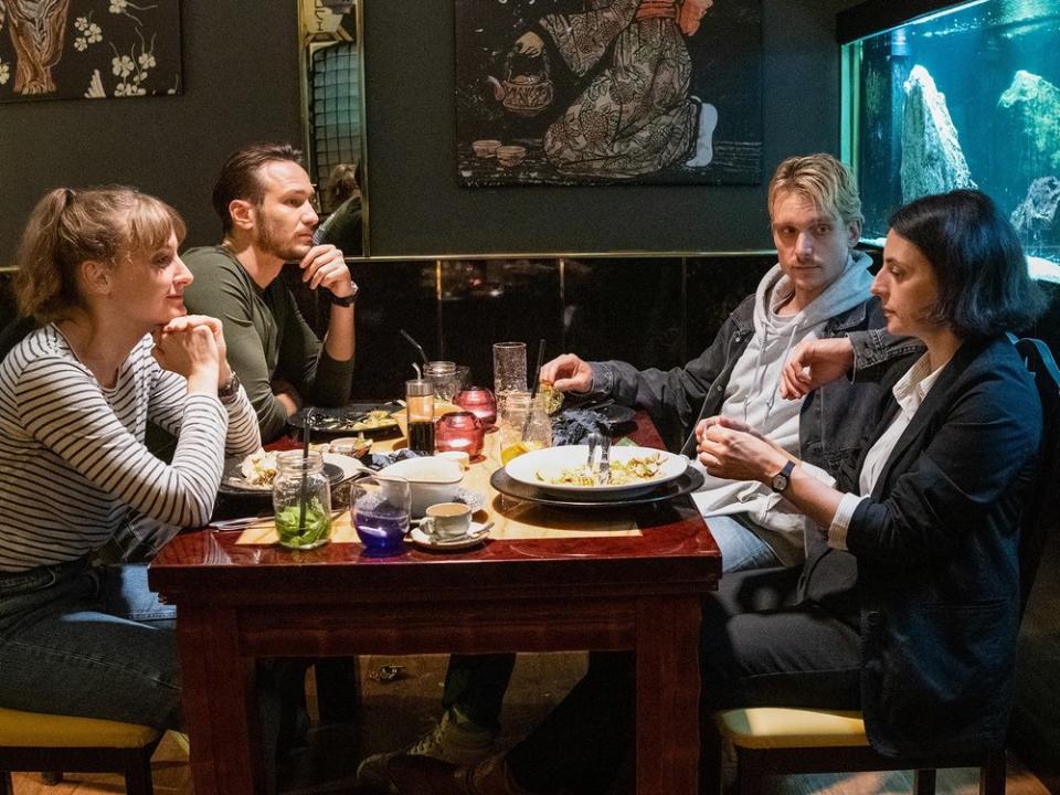 "Tatort: Das Herz der Schlange": Die Hauptkommissarinnen und Hauptkommissare feiern bei einem Abendessen den Abschluss eines Falls: Pia Heinrich (Ines Marie Westernströer, l.), Leo Hölzer (Vladimir Burlakov), Adam Schürk ( Daniel Sträßer, r.), Esther Baumann (Brigitte Urhausen). (Bild: SR/Pasquale D'Angiolillo)