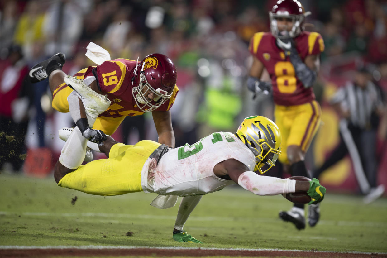 Oregon wide receiver Juwan Johnson, front, dives to score a touchdown past Southern California linebacker Ralen Goforth during the second half of an NCAA college football game Saturday, Nov. 2, 2019, in Los Angeles. (AP Photo/Kyusung Gong)