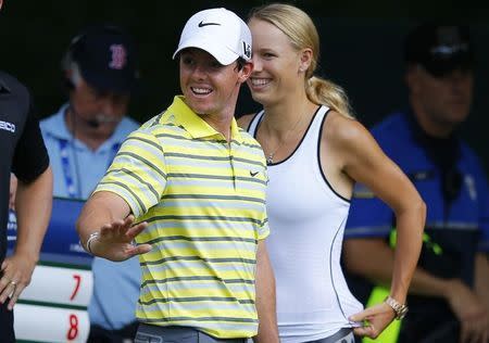 Rory McIlroy of Northern Ireland and his former girlfriend, tennis player Caroline Wozniacki of Denmark, wait at the fourth tee during the final round of the Deutsche Bank Championship golf tournament in Norton, Massachusetts September 2, 2013. REUTERS/Brian Snyder