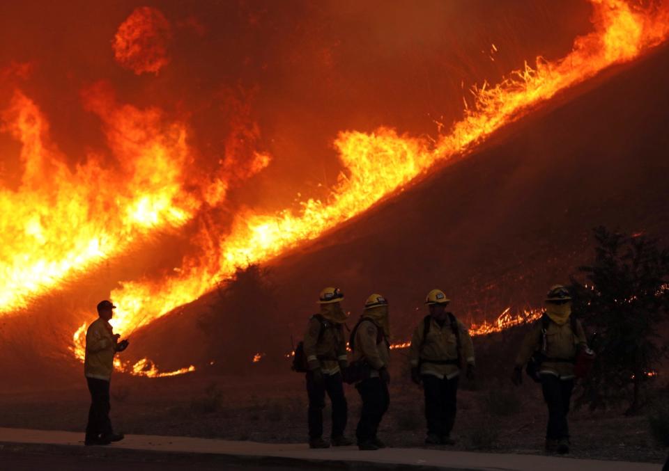 Firefighters working on the Blue Ridge fire conduct a backfire operation Tuesday at Chino Hills State Park in Chino Hills.