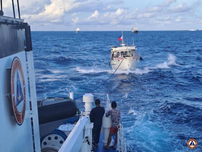 Un buque de la guardia costera filipina remolca un buque de reabastecimiento filipino tras los daños causados por el cañón de agua de un buque de la guardia costera china cuando se dirigía al disputado Second Thomas Shoal, en el Mar de China Meridional