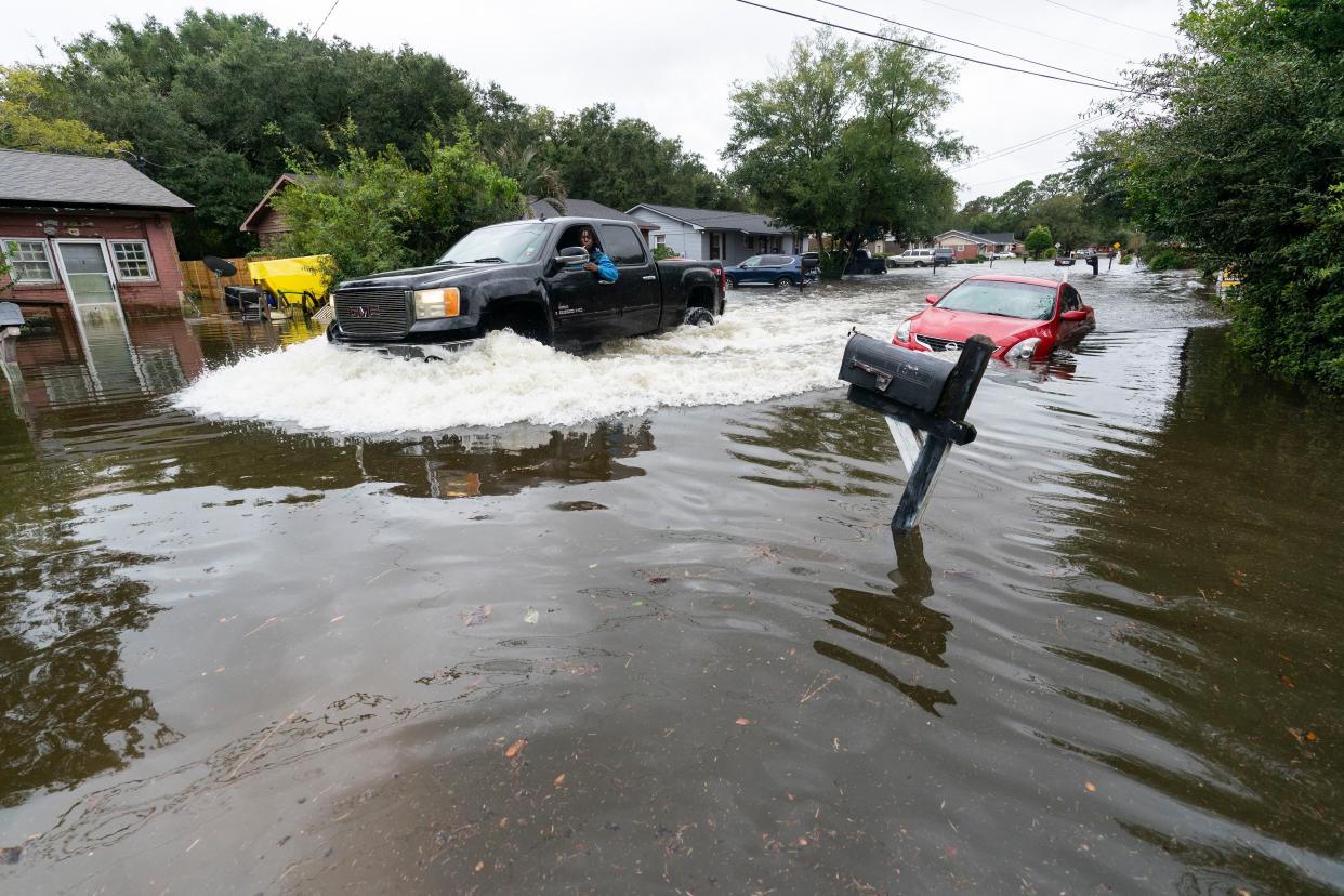 A car drives through high water from the effects from Hurricane Ian, Friday, Sept. 30, 2022, in Charleston, S.C. 