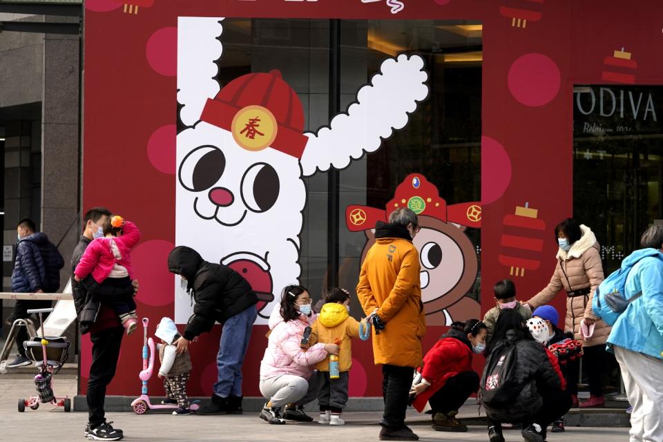 Wuhan residents and their children near Chinese Lunar New Year decorations.