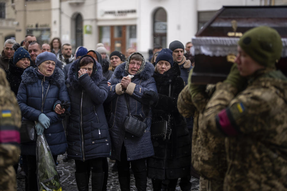 Relatives react as soldiers carry the coffin of Yevhen Zapotichnyi, a Ukrainian military servicemen who were killed in the east of the country, during his funeral in Lviv, Ukraine, Tuesday, Feb 7, 2023. (AP Photo/Emilio Morenatti)