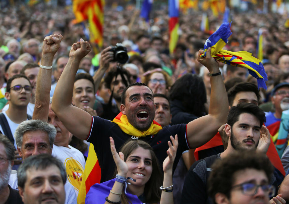 Crowds watching a giant screen showing events inside the Catalan Parliament