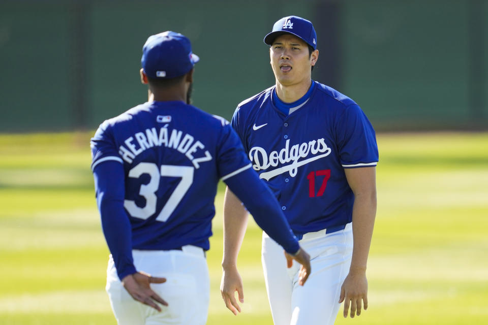 Los Angeles Dodgers designated hitter Shohei Ohtani (17) and right fielder Teoscar Hernández (37) participate in spring training baseball workouts at Camelback Ranch in Phoenix, Wednesday, Feb. 14, 2024. (AP Photo/Ashley Landis)