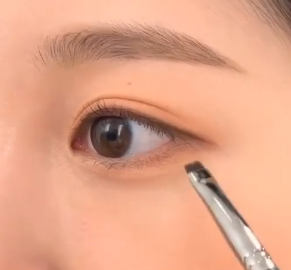 用扁刷沾取深棕色的眼影細細描繪在眼線外緣  圖片來源：IG@chahong_official