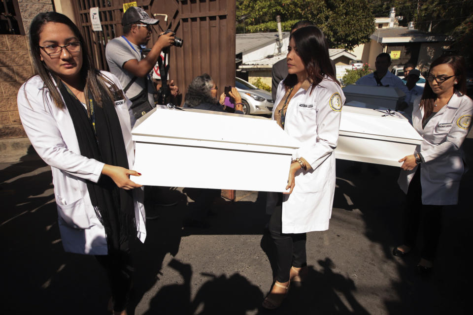 Small coffins holding the remains of three of six family members who were killed in a 1982 massacre are carried by workers from the forensic office to be handed over to the victims' family in San Salvador, El Salvador, Thursday, Jan. 23, 2020. The remains of six adults and children from one family were handed over to surviving relatives Thursday, 38 years after the El Calabozo massacre, in which government soldiers are accused of killing more than 200 people. (AP Photo/Salvador Melendez)