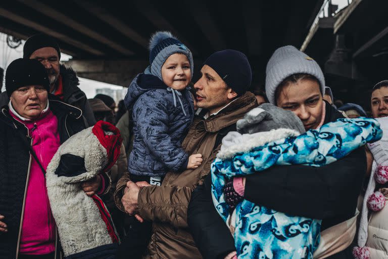 Varias personas con niños esperan para cruzar el río de Irpin, a 5 de marzo de 2022, en Irpin 