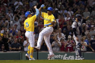 Boston Red Sox's Rafael Devers, center, celebrates with teammate Enrique Hernandez (5) after Hernandez scored on a three-run home run by Devers as New York Yankees catcher Kyle Higashioka, right, looks to the field during the sixth inning of a baseball game at Fenway Park, Friday, Sept. 24, 2021, in Boston. (AP Photo/Mary Schwalm)