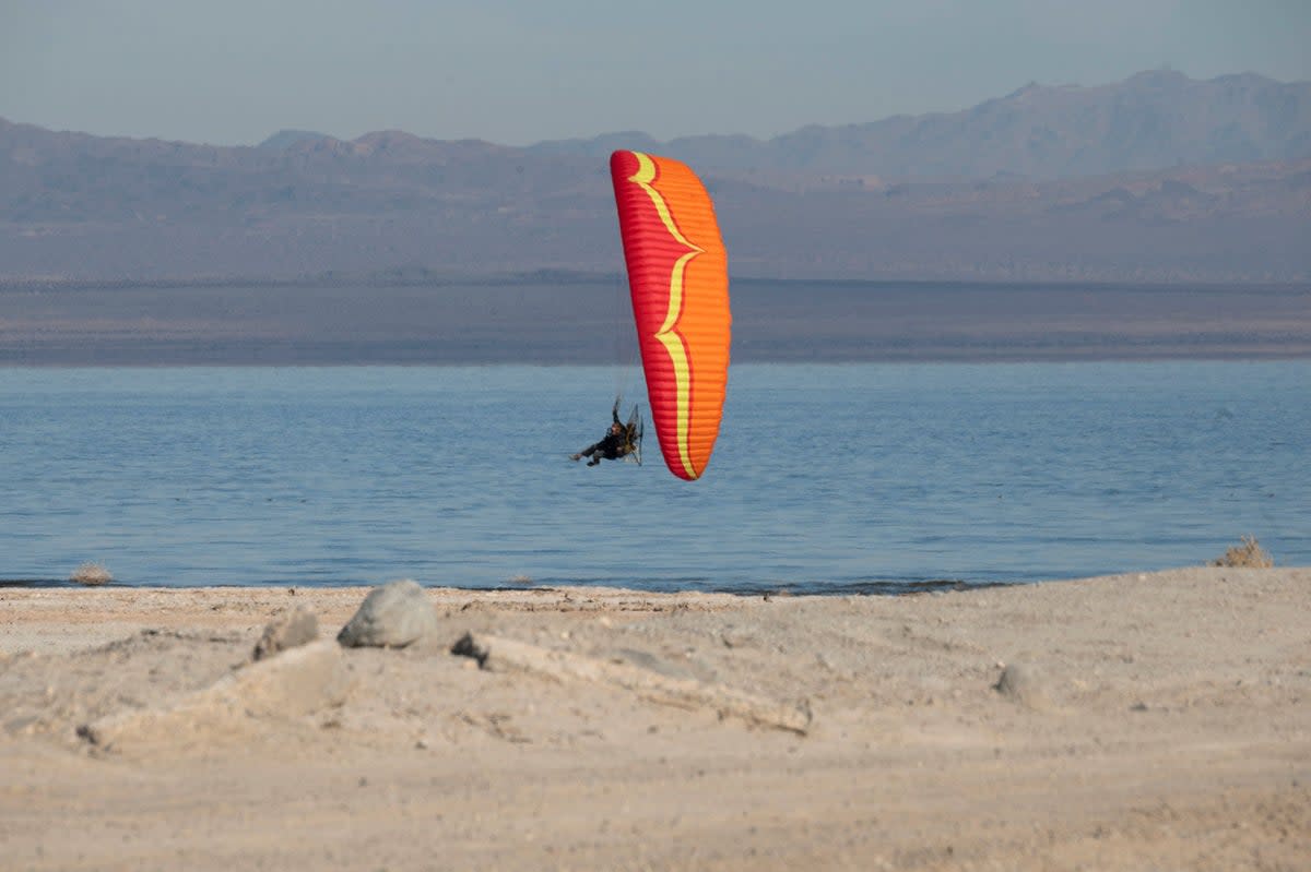 A man rides a paramotor over the Salton Sea in Salton City, California, December 16, 2021 (AFP via Getty Images)