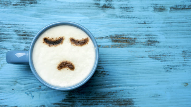 cup of cappuccino with a sad face