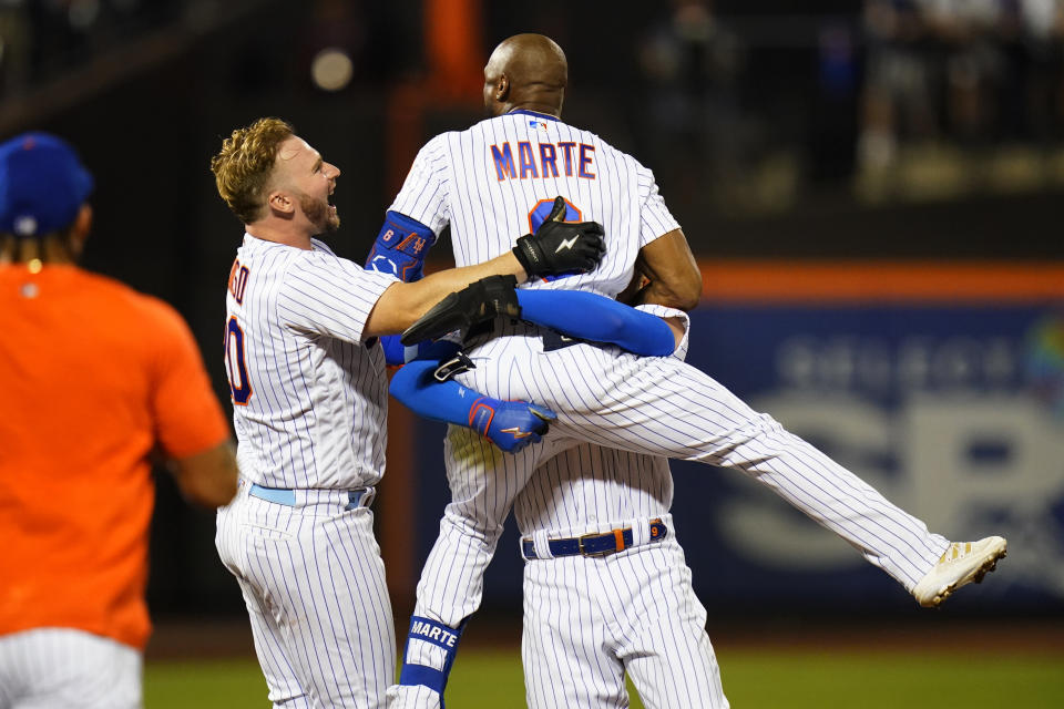 New York Mets' Pete Alonso (20) celebrates with Starling Marte after Marte hit an RBI single during the ninth inning of the team's baseball game against the New York Yankees on Wednesday, July 27, 2022, in New York. The Mets won 3-2. (AP Photo/Frank Franklin II)