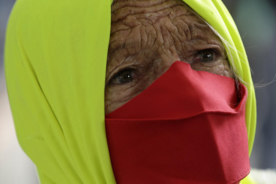 An elderly woman participates in a protest against Brazilian President Jair Bolsonaro's handling of the coronavirus in Brazilia, Brazil, Wednesday, Dec. 23, 2020. Protesters also called for the immediate start of COVID-19 vaccinations. (AP Photo/Eraldo Peres)