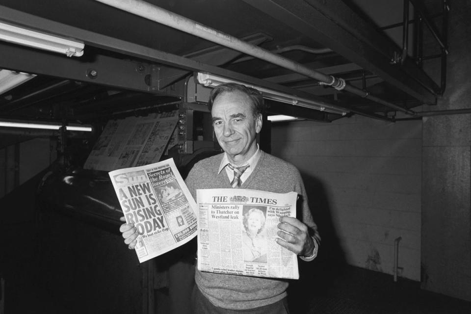 1986: Newspaper proprietor Rupert Murdoch holds copies of The Sun and Times papers, at his new high technology print works in Wapping, East London: (PA)