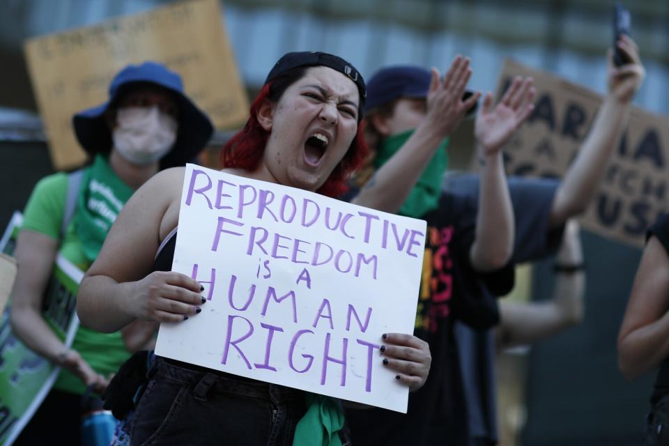 A protester holding a sign chants